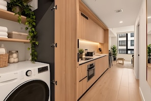 Une cuisine moderne avec des meubles en bois, un four encastré et un plan de travail.