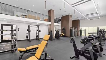 Academia moderna com diversos equipamentos de exercício, incluindo aparelhos de musculação e pesos livres.