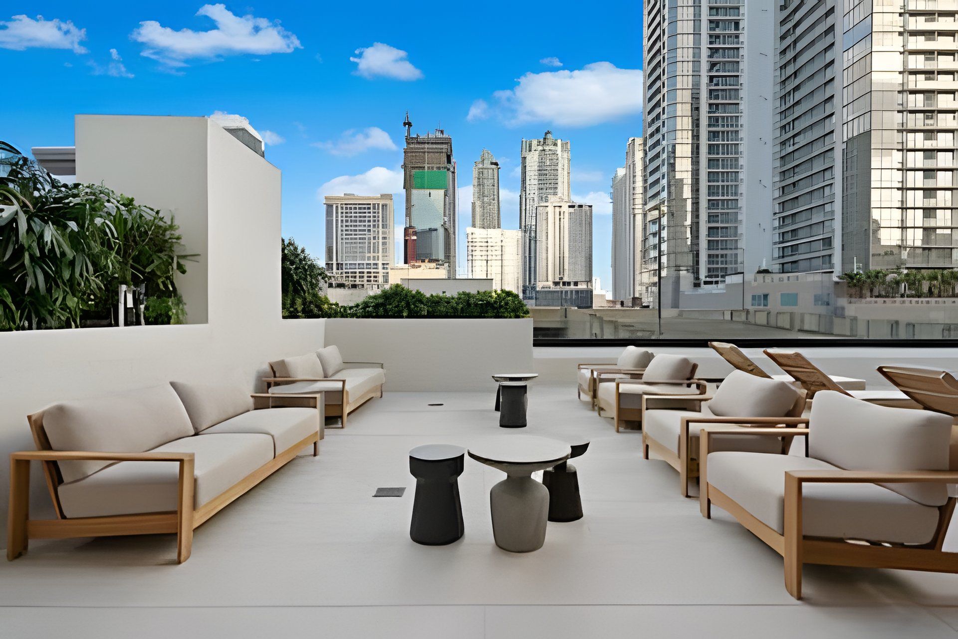 A rooftop terrace with multiple seating areas, a view of the city skyline, and a mix of modern and traditional architecture.