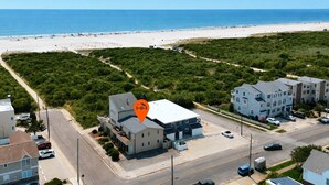 A coastal residential area with a beachfront, a large building with a flat roof, and a parking lot. - Beach Block Brigantine Condo | Steps to Sand (Brigantine)