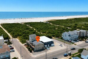 A coastal residential area with a beachfront, a large building with a flat roof, and a parking lot. - Beach Block Brigantine Condo | Steps to Sand (Brigantine)