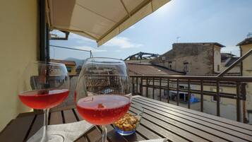 Un balcone con due bicchieri da vino e una ciotola di frutta secca.