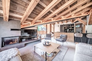 Ein moderner Wohnraum mit Kamin, Sitzecke und Bar.