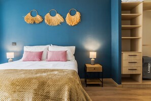 Ein Schlafzimmer mit einem Bett, Nachttischlampen, einem Nachttisch, einem an der Wand befestigten Regal und einem Kleiderschrank.