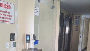 A hotel entrance with a metal gate, a reception desk, and a sign on the wall. - Located in Bairro Turista II, Flat 408 in Caldas Novas, 600 meters from Shopping Singapura. (Caldas Novas)