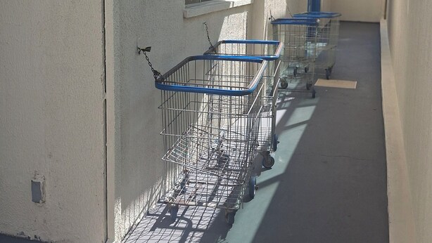A narrow corridor with a series of metal shopping carts lined up against a wall. - Located in Bairro Turista II, Flat 408 in Caldas Novas, 600 meters from Shopping Singapura. (Caldas Novas)