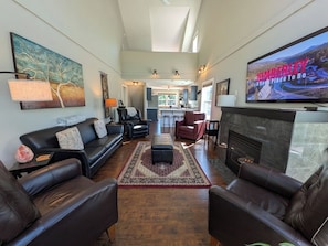 A spacious living room with leather sofas, a fireplace, and a television. - Kimberley Mountain Getaway | Ski, Golf & Adventure (Kimberley)