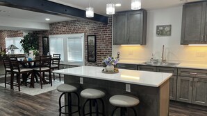 A modern kitchen with a central island, bar stools, and pendant lighting. - Perfect 2-bedroom apartment near all attractions in downtown STL. Arch views! (St. Louis)