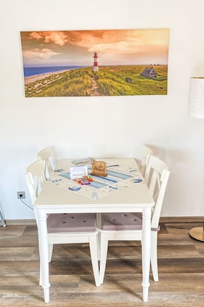 Een eettafel met een placemat, een houten bordje en enkele spullen erop.