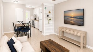 Uma sala de estar moderna com um sofá, uma mesa de centro e um quadro na parede.