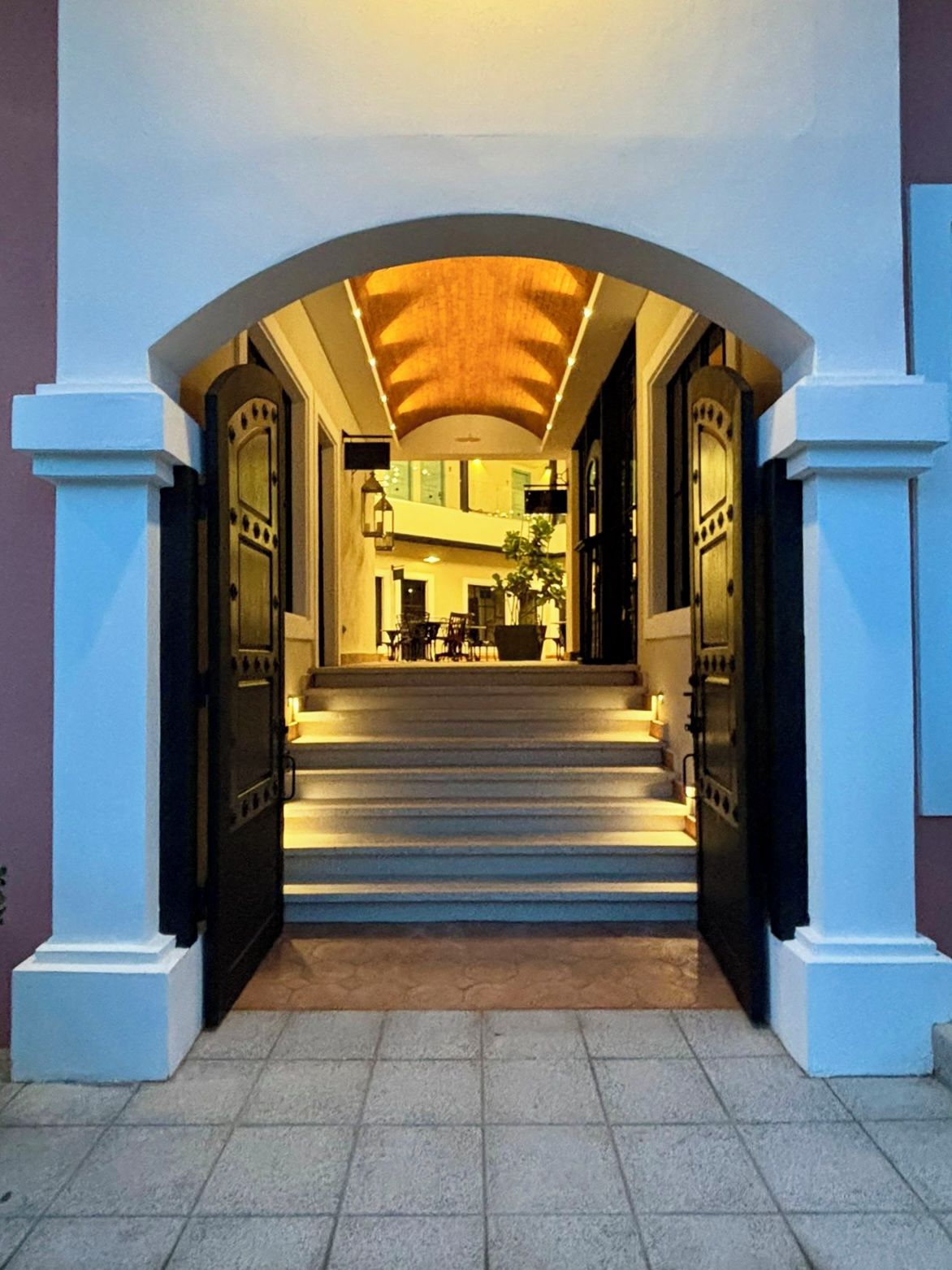 A hotel entrance with a staircase leading to a reception area.