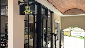 Entrada de un hotel con un letrero que dice 'CASONA Boutique Hotel', techo de tejas y vista a la calle.