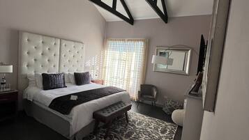 Un dormitorio con una cama grande, un banco, un escritorio y una silla.