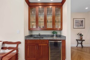 A kitchen with wooden cabinets, a granite countertop, and a stainless steel dishwasher. - Nordhaus | Walk to Beach | Hot Tub | Private Yard! (South Haven)