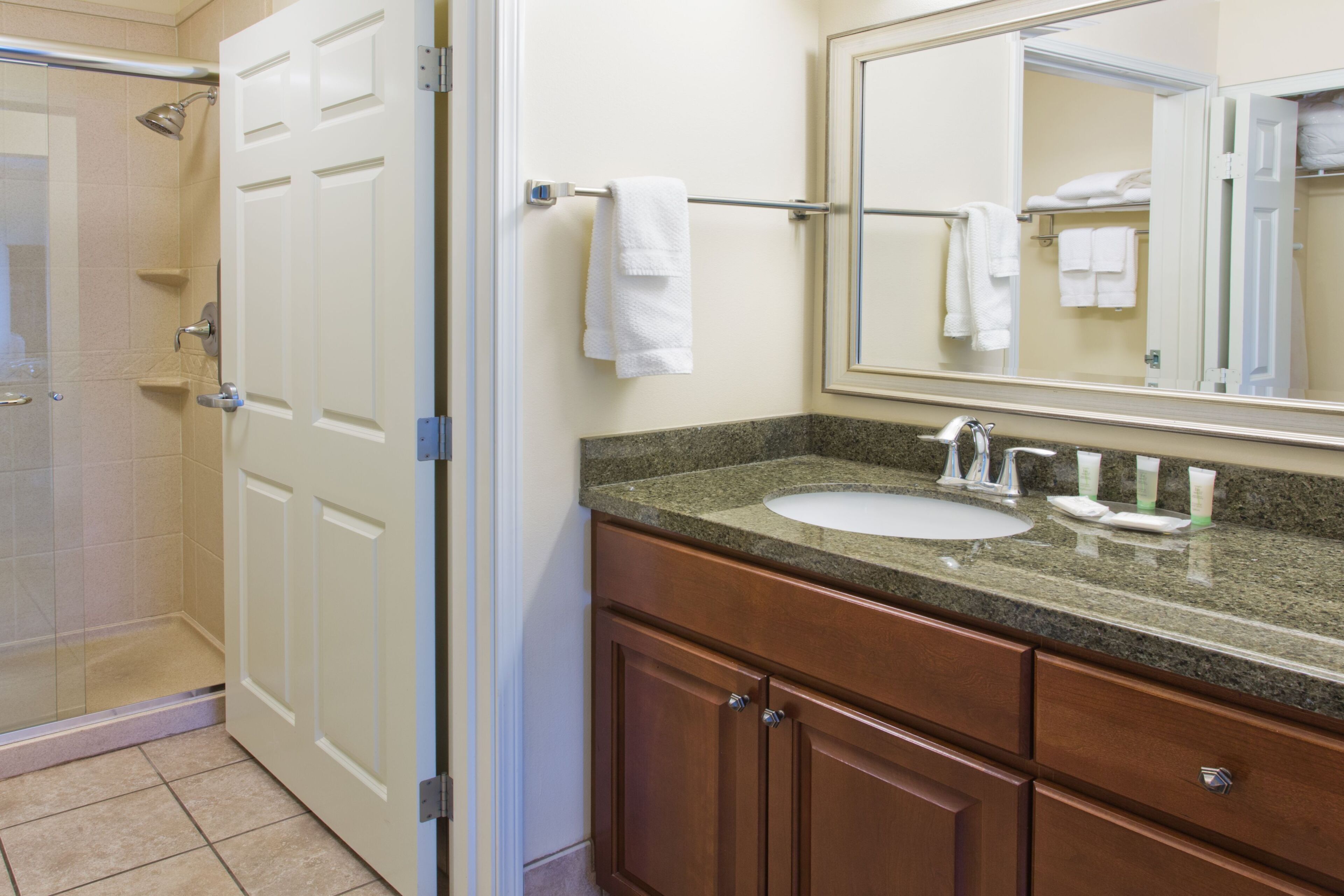Une salle de bain avec une douche, un lavabo et un meuble-lavabo avec un miroir.