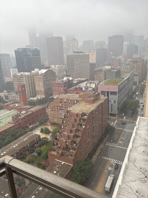 A cityscape with high-rise buildings, a prominent red brick building with a clock tower, and a street with vehicles. - Luxury 1BR Chicago Retreat downtown  Free Parking, Gym, Theater & Patio (Chicago)