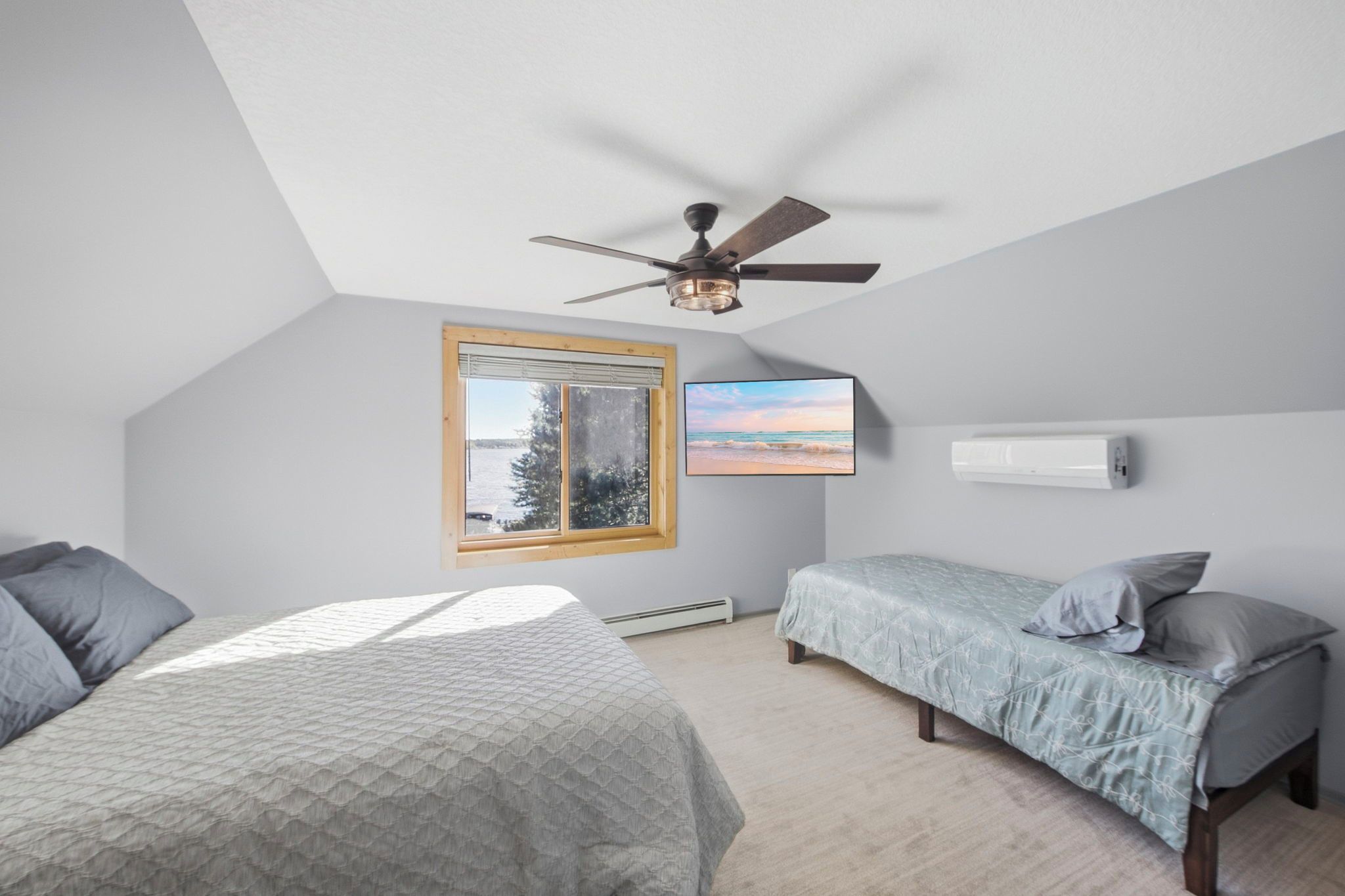 Une chambre avec deux lits, un ventilateur de plafond, une fenêtre avec vue et un climatiseur fixé au mur.