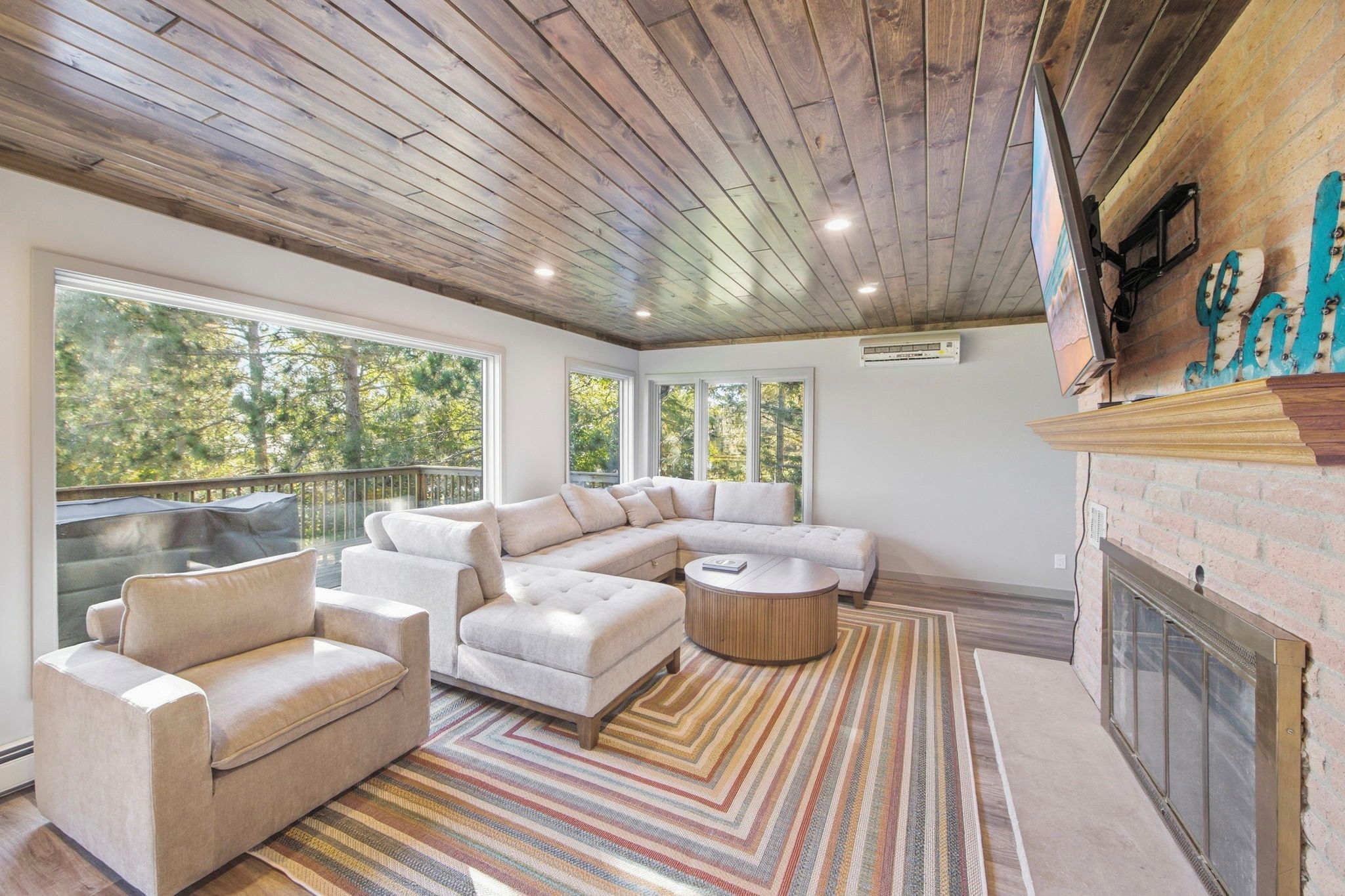 A modern living room with a sectional sofa, a round coffee table, and a fireplace.