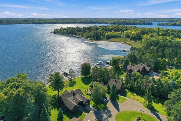 A lakeside property with multiple cabins, a dock, and a boat.