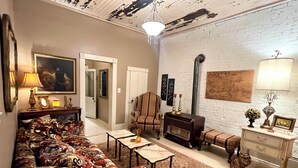 Una sala de estar con sofá, sillones, chimenea y una estatua de gato.