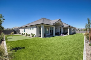 A modern two-story house with a well-maintained lawn and a patio area. - Red Rock Retreat - 4BR - Hot Tub - Fire Pit (Hurricane)