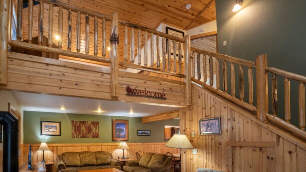Un intérieur en bois avec un escalier, un canapé et une lampe.