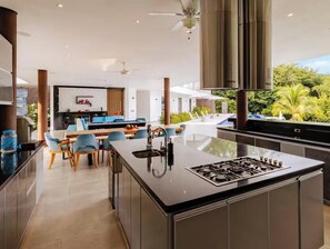 A modern kitchen with a central island, a dining area with chairs, and a view of greenery outside. - Sensacional TopSpot® muy Cerca de Payandé-Villeta (Nimaima)