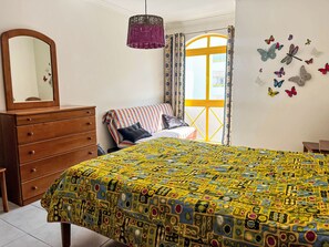 A bedroom with a bed, dresser, and a window with curtains. - Apartment with Pool View by Interhome (Quarteira)