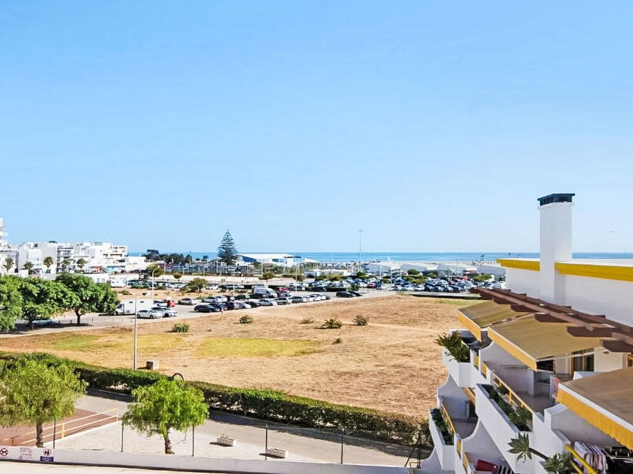 Une vue sur la côte, avec un parking, des bâtiments et un ciel dégagé.