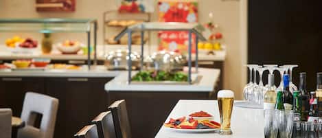 A buffet table with various food items and a selection of alcoholic beverages.