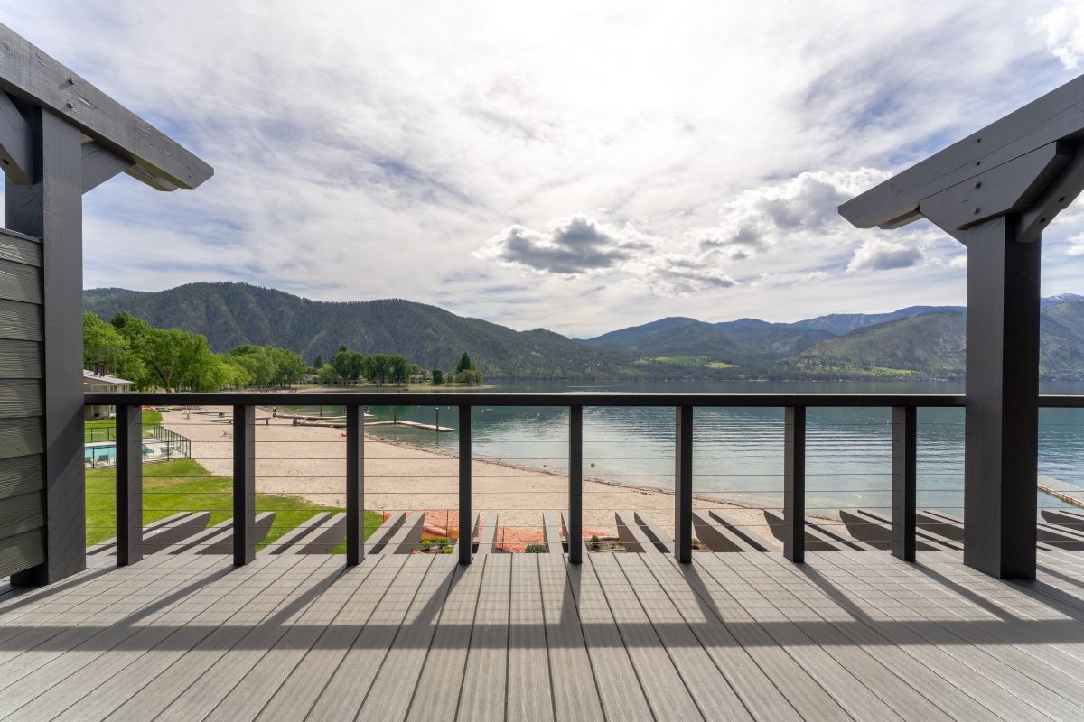 A wooden deck with a view of a lake and mountains.