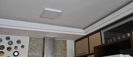 A kitchen with a stainless steel range hood, a white refrigerator, a microwave, and a coffee maker on the counter.