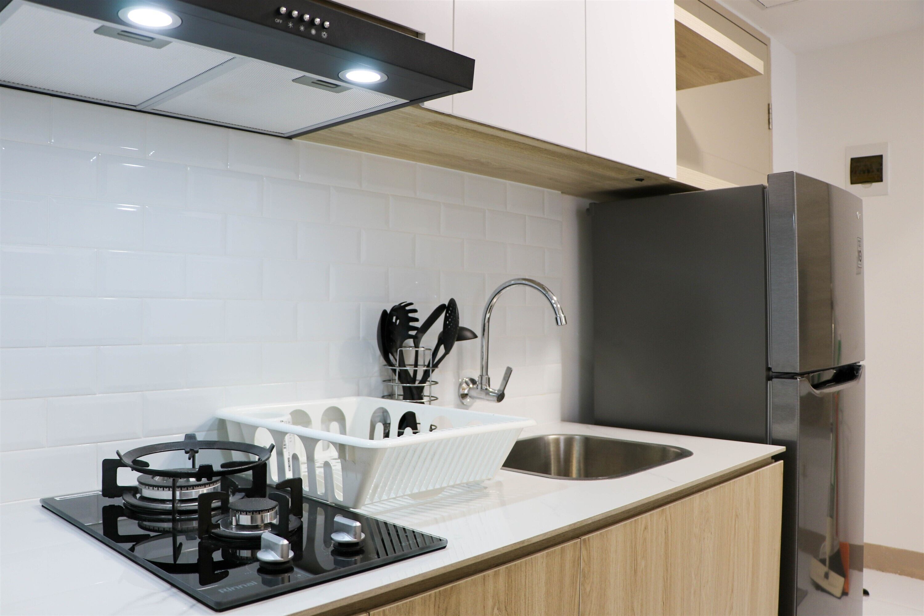 Een moderne keuken met een gasfornuis, een roestvrijstalen spoelbak en een ingebouwde koelkast.