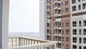 A multi-story residential building with balconies and a view of a distant landscape. - Pleasurable And Modern 2Br Tokyo Riverside Pik 2 Apartment (Teluknaga)
