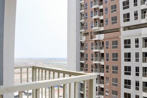 Un immeuble résidentiel à plusieurs étages, doté de balcons et offrant une vue sur un paysage lointain.