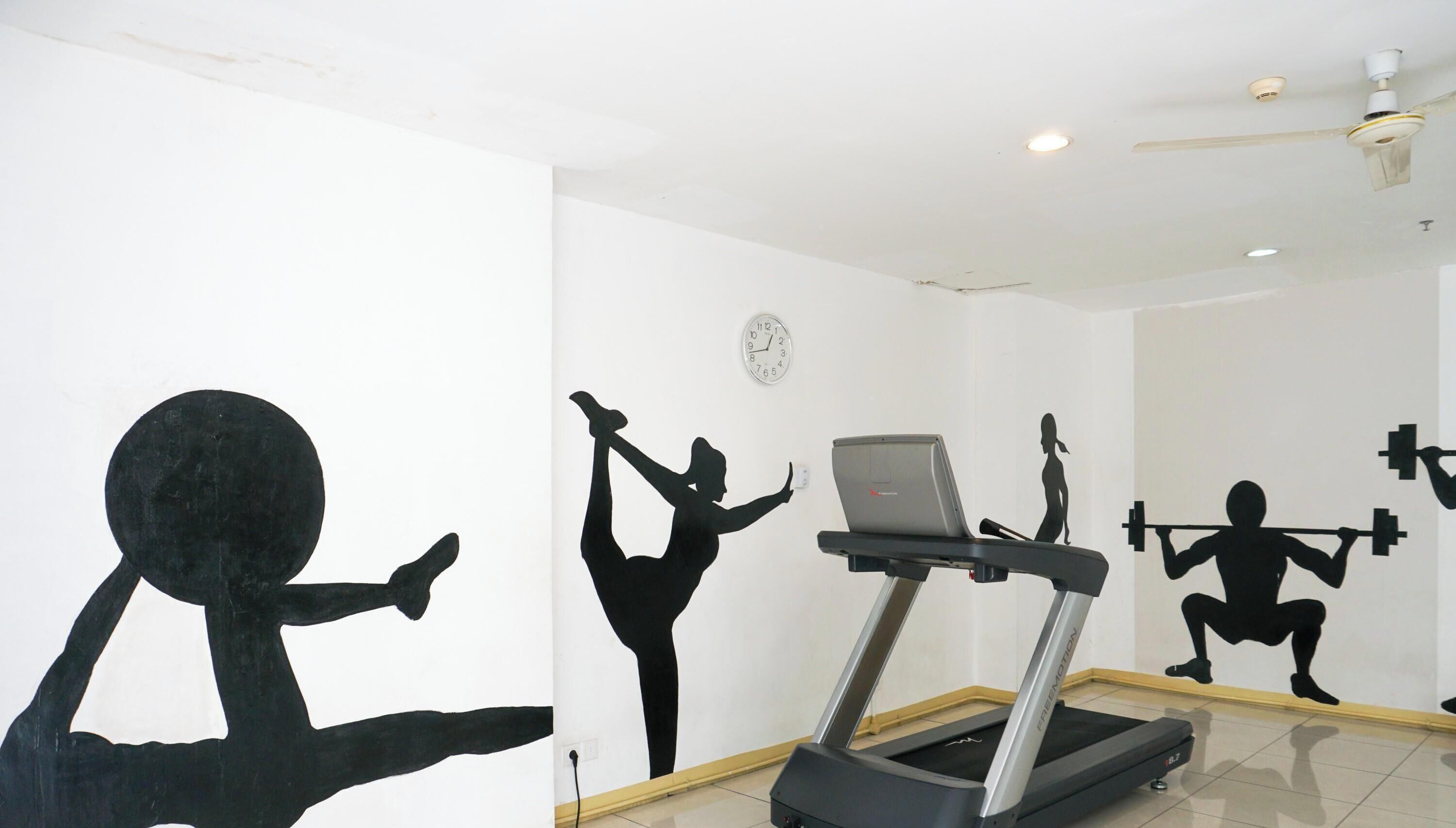 Un gimnasio con una cinta de correr, un reloj de pared y siluetas de personas haciendo ejercicio.
