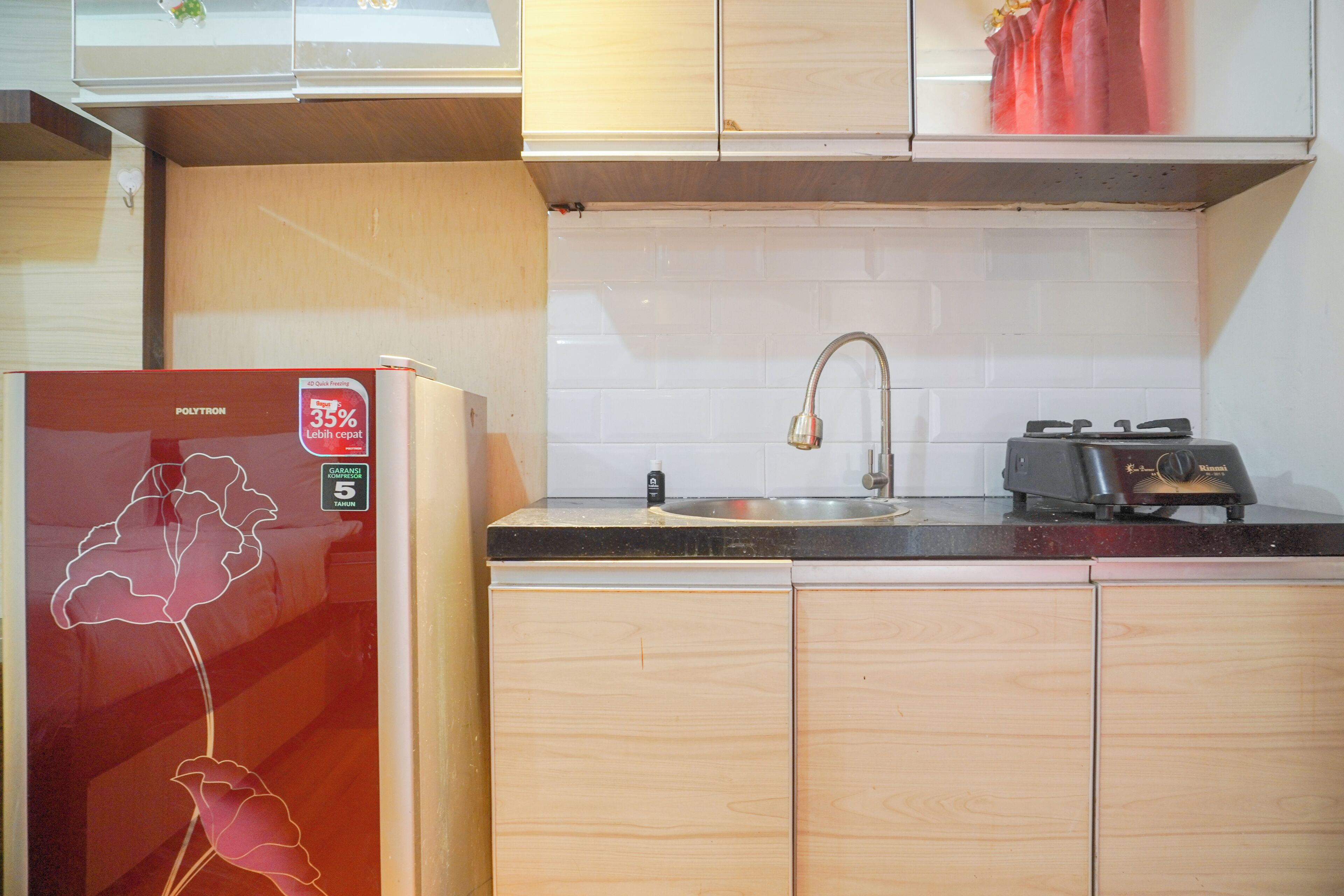 Una cocina compacta con refrigerador, pileta y estufa.