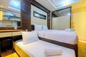Ein Hotelzimmer mit Bett, Sessel, Spiegel und Kleiderschrank.