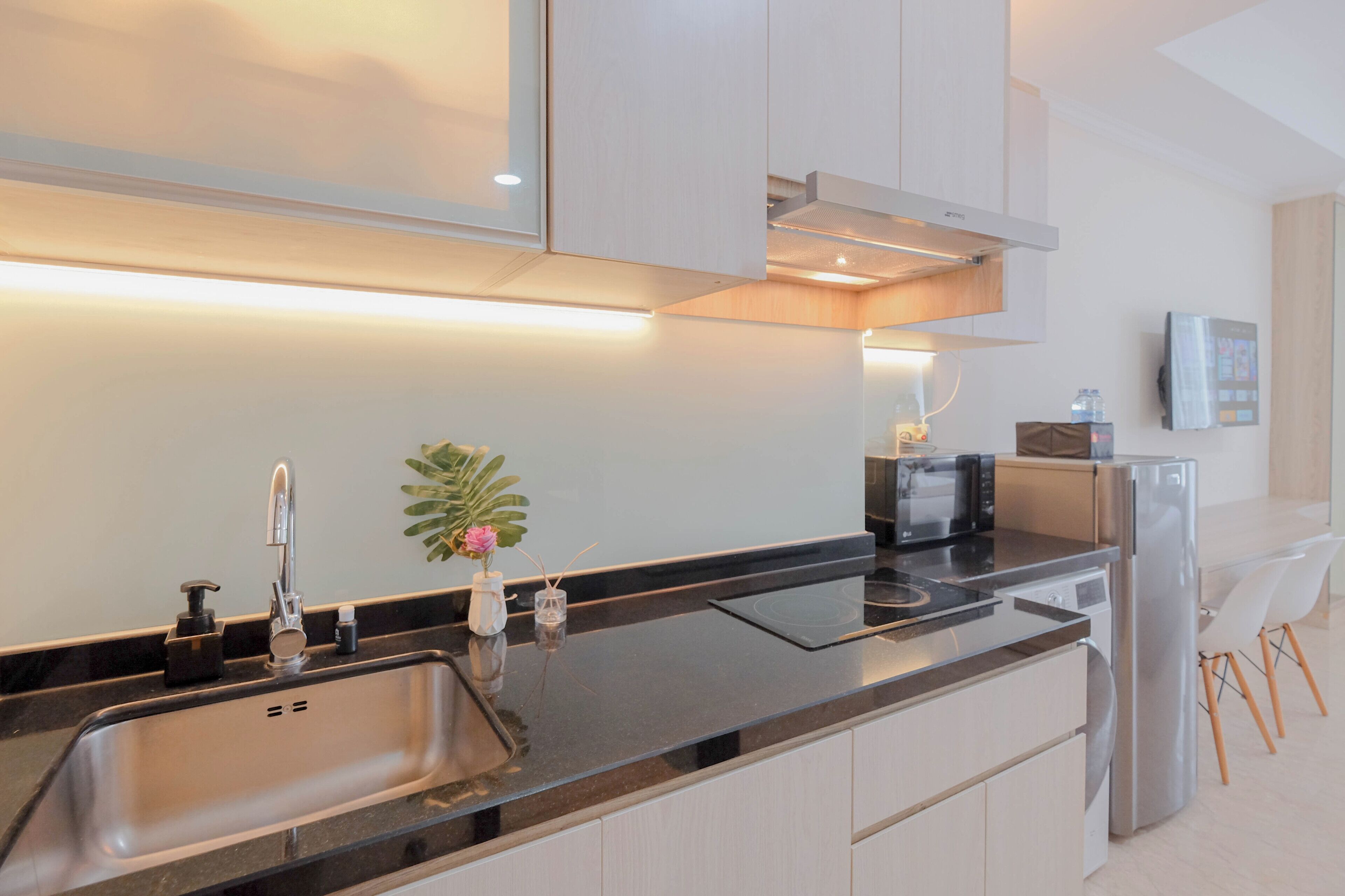 Una cocina moderna con horno empotrado, microondas y refrigerador.