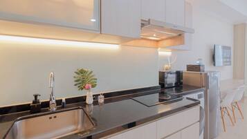 Una cocina moderna con horno empotrado, microondas y refrigerador.