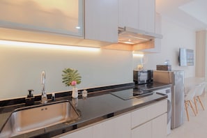 Una cocina moderna con horno empotrado, microondas y refrigerador.