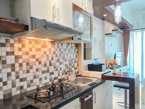Une cuisine moderne avec un dosseret carrelé, des appareils en acier inoxydable et un coin bar équipé d’un évier et d’un plan de travail.