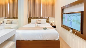 A hotel room with a large bed, bedside tables, a TV, and curtains. - Minimalist And Good Place 1Br At Signature Park Grande Apartment (Jakarta)