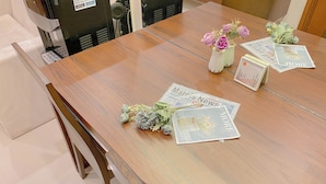 A wooden table with newspapers and floral arrangements. - Minimalist And Good Place 1Br At Signature Park Grande Apartment (Jakarta)