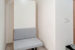 A room with a grey bench, a wardrobe, and a wall-mounted telephone. - Restful Living Studio (No Kitchen) At Apartment Bandaraya - Tallasa City Makassar (Makassar)