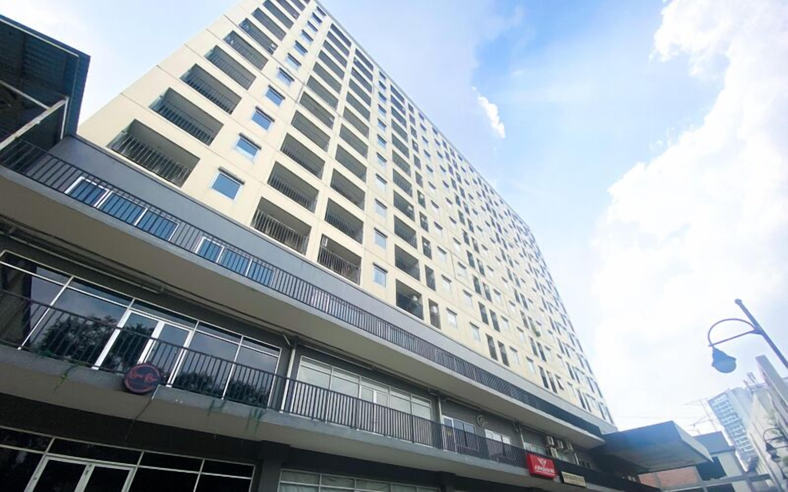 A multi-story building with balconies and large windows.
