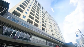 A multi-story building with balconies and large windows.