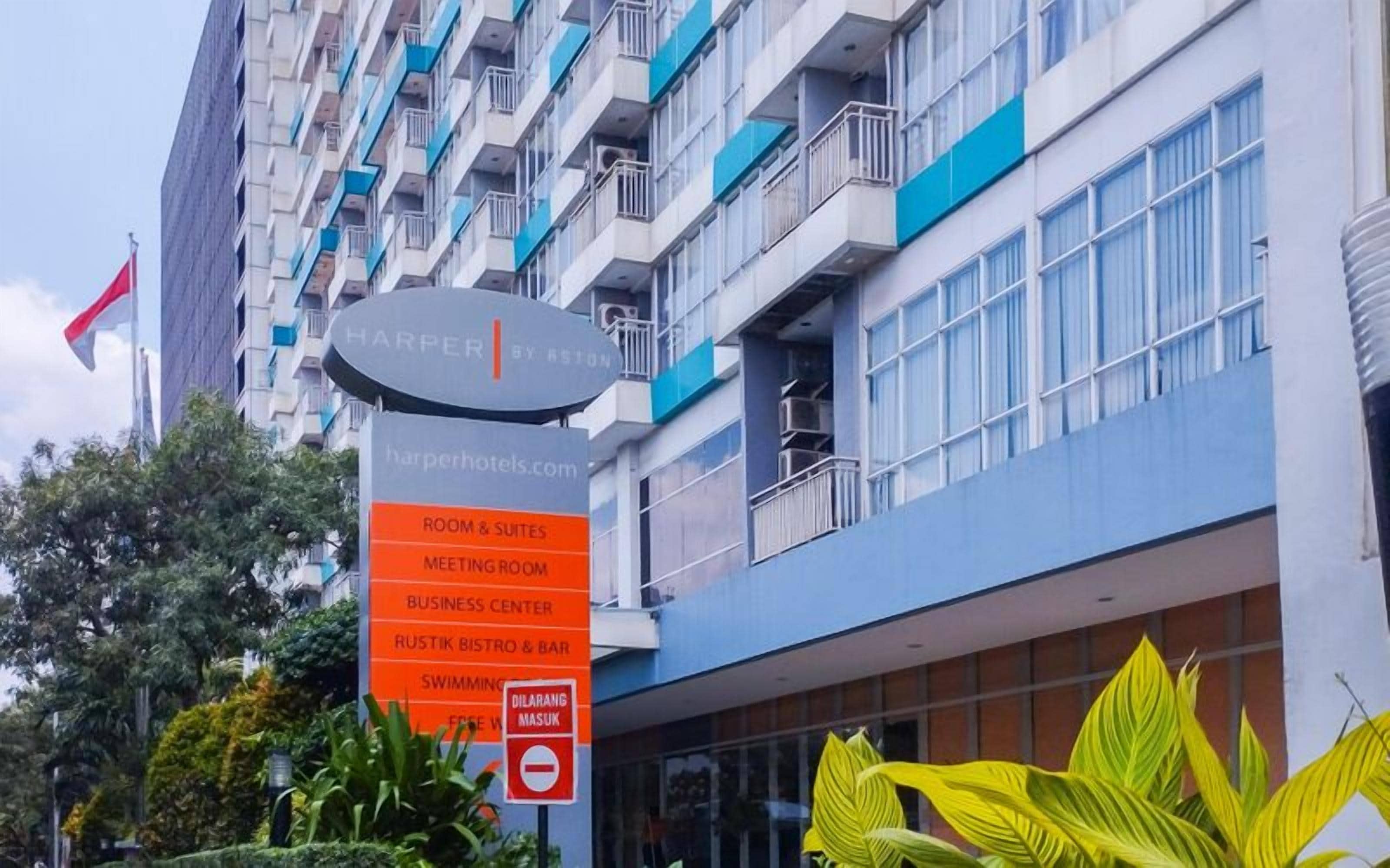 A hotel sign with "Harper by RSTON" and a list of amenities including room & suites, meeting room, business center, Rustik Bistro & Bar, and swimming pool.