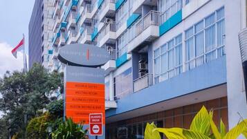 A hotel sign with "Harper by RSTON" and a list of amenities including room & suites, meeting room, business center, Rustik Bistro & Bar, and swimming pool.