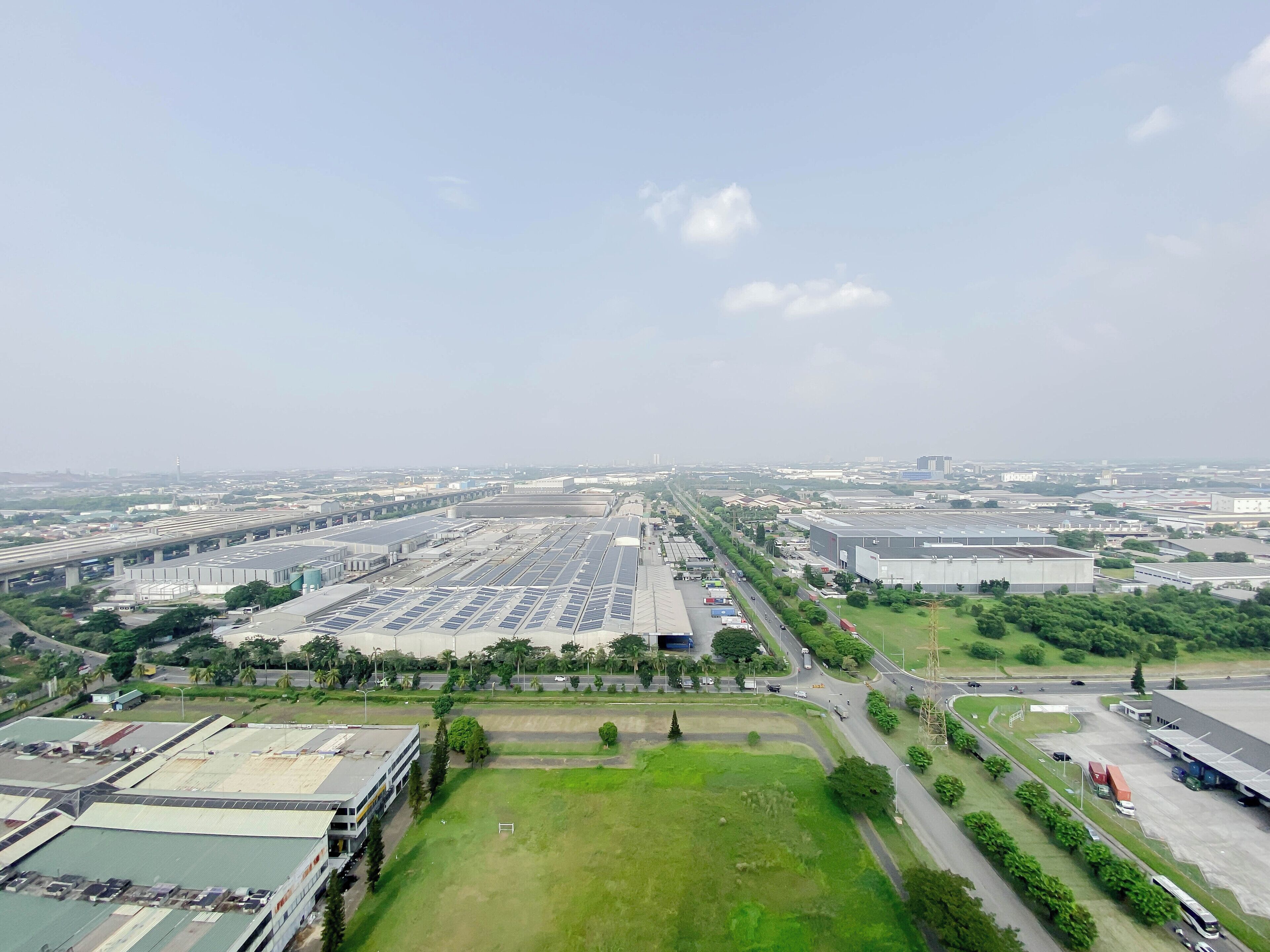 Une zone industrielle comprenant de nombreux entrepôts, des routes et des espaces verts.